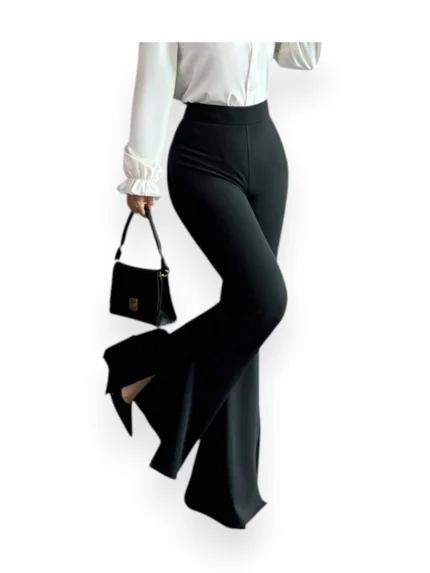 Woman wearing black high waist flare pants in heavy diving fabric, front walking pose with handbag.