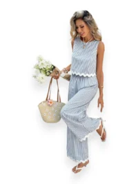 Woman wearing Luna Stripe Wide-Leg Set with scalloped hem and elastic waist, holding a straw bag and white flowers.