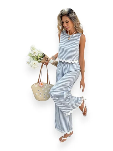 Woman wearing Luna Stripe Wide-Leg Set with scalloped hem and elastic waist, holding a straw bag and white flowers.